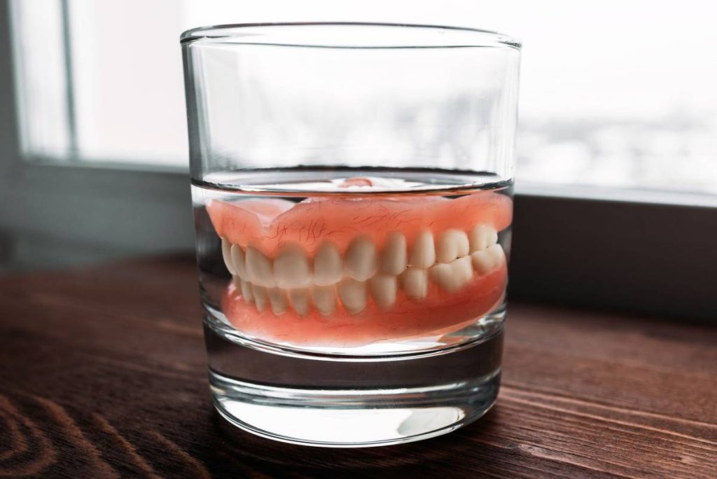 Dentadura Postiza en un vaso con agua