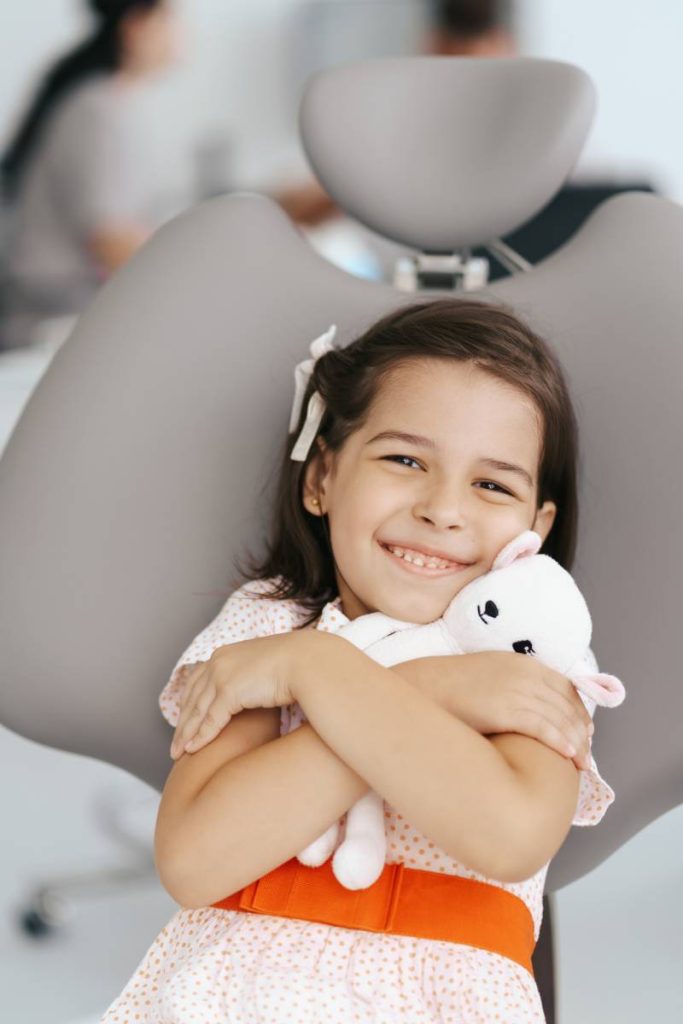 Smiling cute girl in dentist chair
